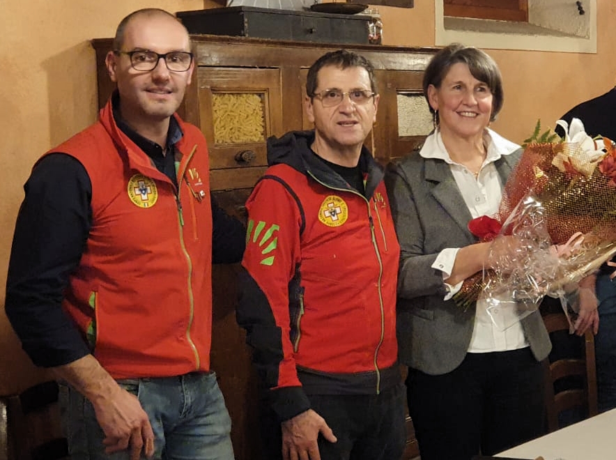 Il delegato del Soccorso alpino bellunese, Alex Barattin e il presidente Rodolfo Selenati premiano la storica segretaria Grazia Rizzi