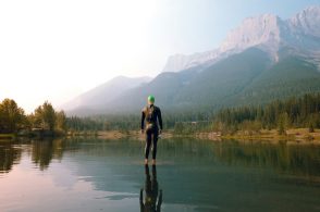 man in black jacket and black pants standing on water during daytime