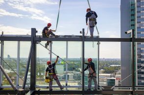 a group of men standing on top of a tall building