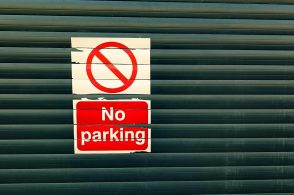 No parking sign on a green corrugated wall