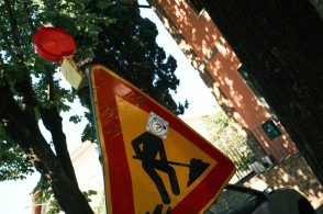 Road work sign with a masked figure shoveling